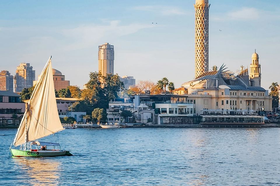 فلوكة في النيل وخلفها برج القاهرة